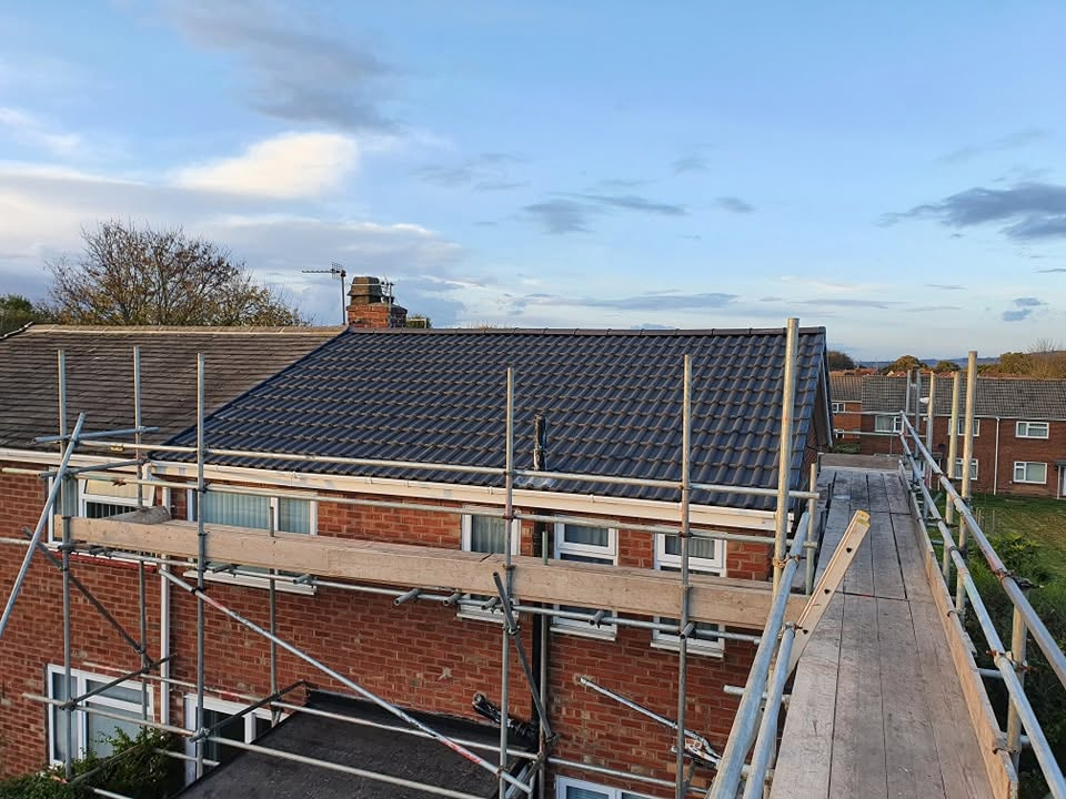 Scaffolded semi-detached house with finished new roof